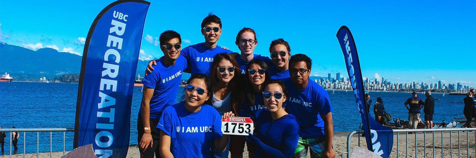A group of students posed in front of the Vancouver skyline at Waterfront.