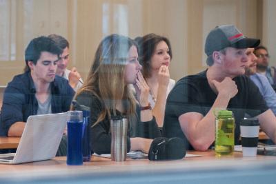 Students sitting in a row with their laptops.