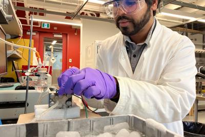 A researchers adjusts a CO2 electrolyzer powered by thermoelectric generators in a lab.