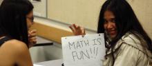 A student holds up a math is fun sign.