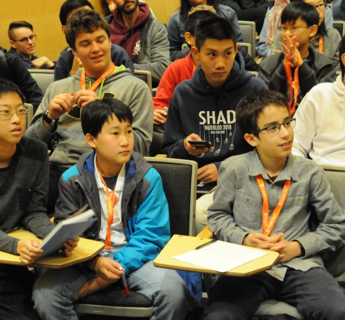 Group of grade school students sitting in a lecture hall